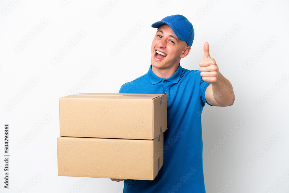Young delivery Brazilian man isolated ops white background with thumbs up because something good has happened Young delivery Brazilian man isolated ops white background with thumbs up because something good has happened