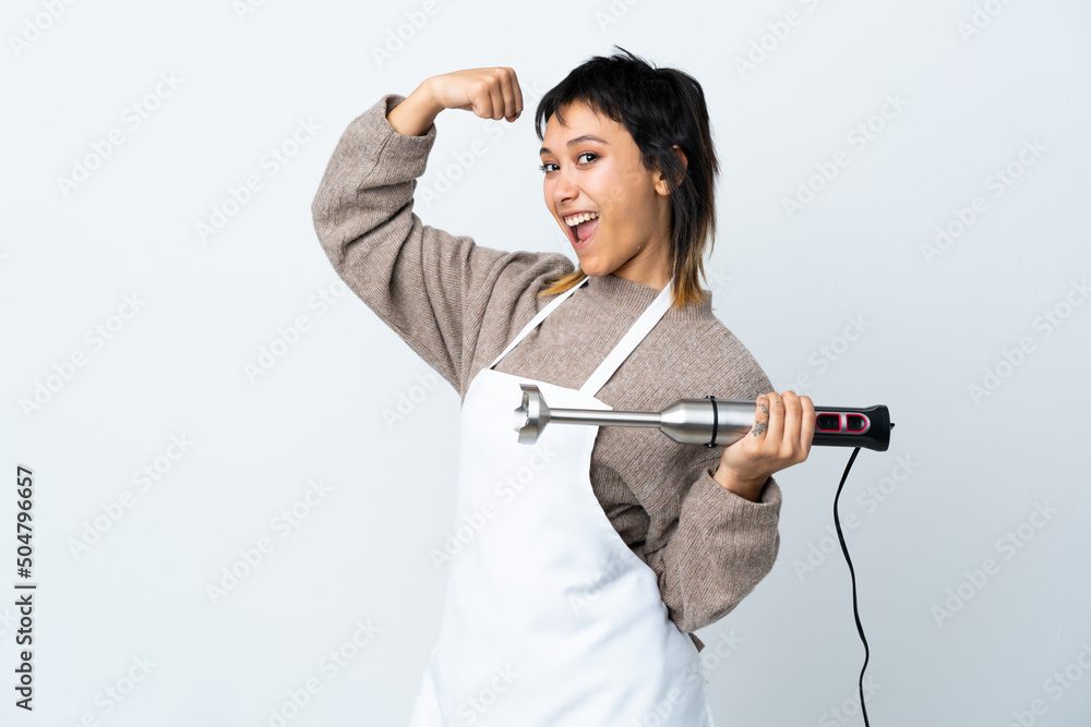 Chef Uruguayan girl using hand blender over isolated white background making strong gesture Chef Uruguayan girl using hand blender over isolated white background making strong gesture