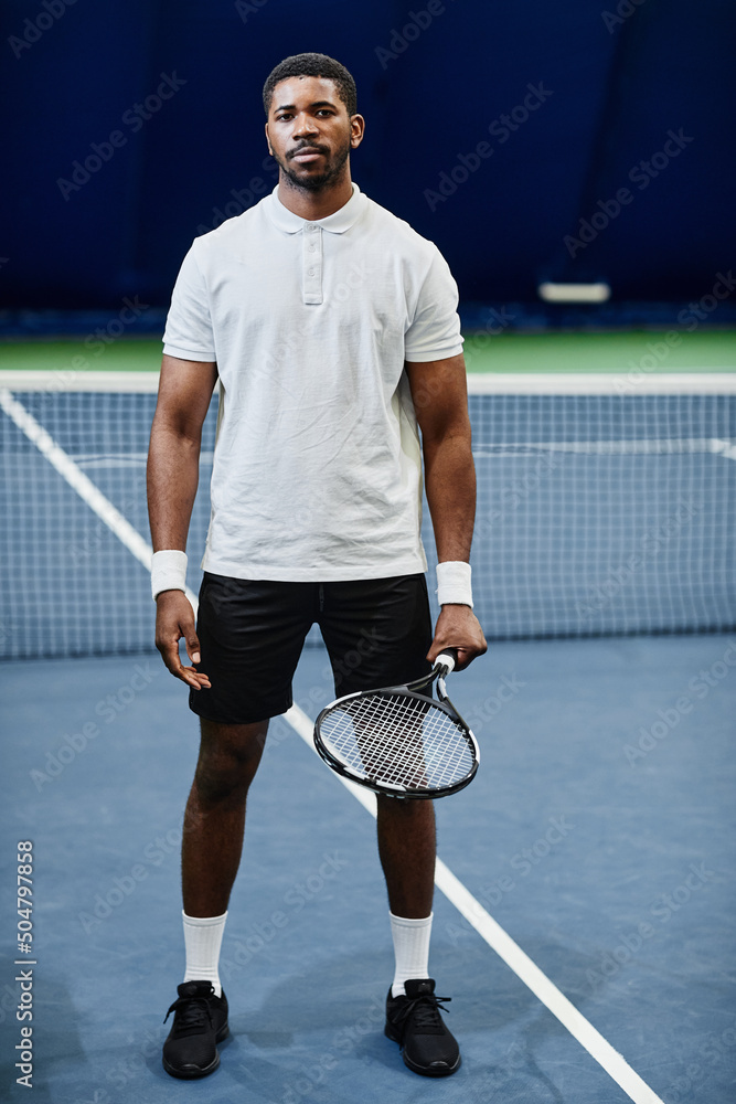 Full length portrait of African American tennis player looking at camera  while posing confidently with racket at indoor court Stock Photo | Adobe  Stock