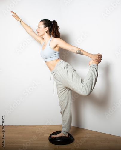 Tablou canvas giovane studentessa che fa ginnastica su sfondo neutro