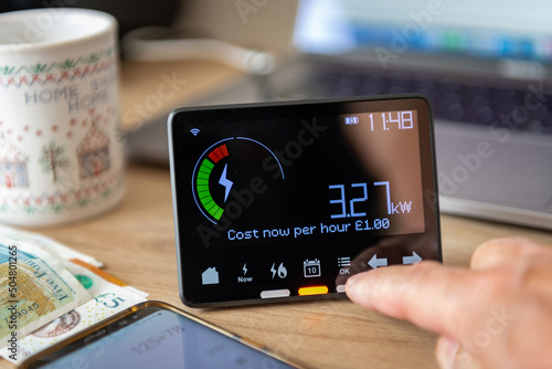 A person checking and calculating rising home energy cost with smart meter. Inflation, cost of living concept. photo