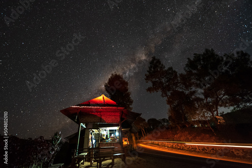 Milky way over small stall that selling traditional indonesian food, coffee and instant noodles, a night in Pangalengan Bandung, Indonesia photo