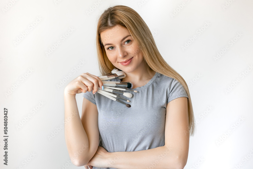 Makeup artist with brushes in hand on a white background Makeup artist with brushes in hand on a white background