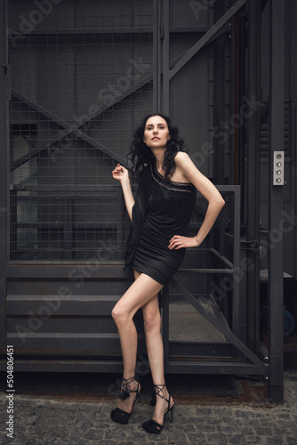 A brunette girl with long legs stands near a freight elevator