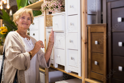 Fotografie, Obraz Elderly female shopper choosing dressing table in furniture shop