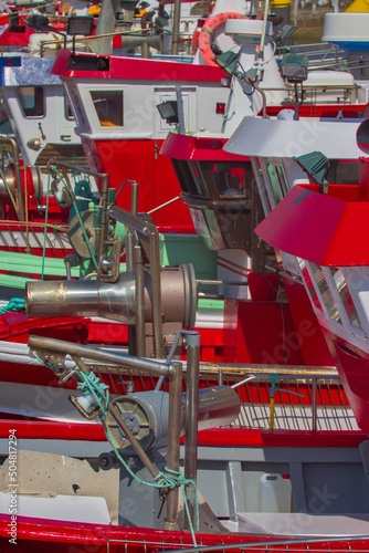 Several red fishing boats moored in a harbour in Spain, Europe