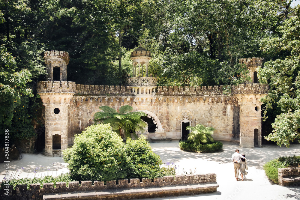 Obraz premium Portal of guardians and walking couple in Quinta da Regaleira in Sintra