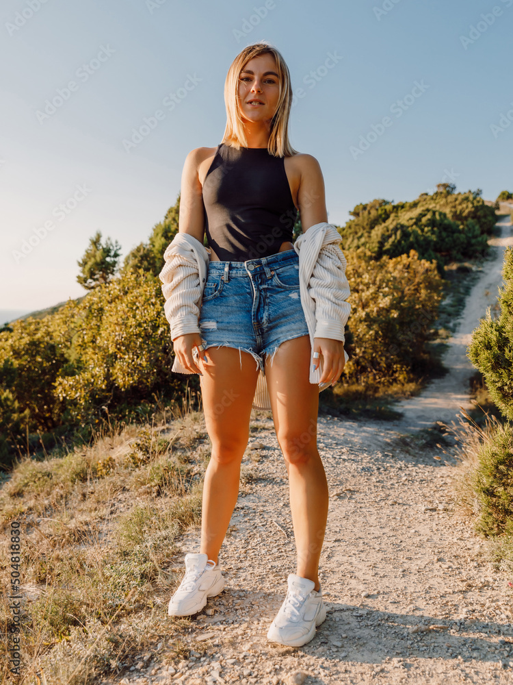 Attractive young woman in shorts posing outdoor. Attractive young woman in shorts posing outdoor.
