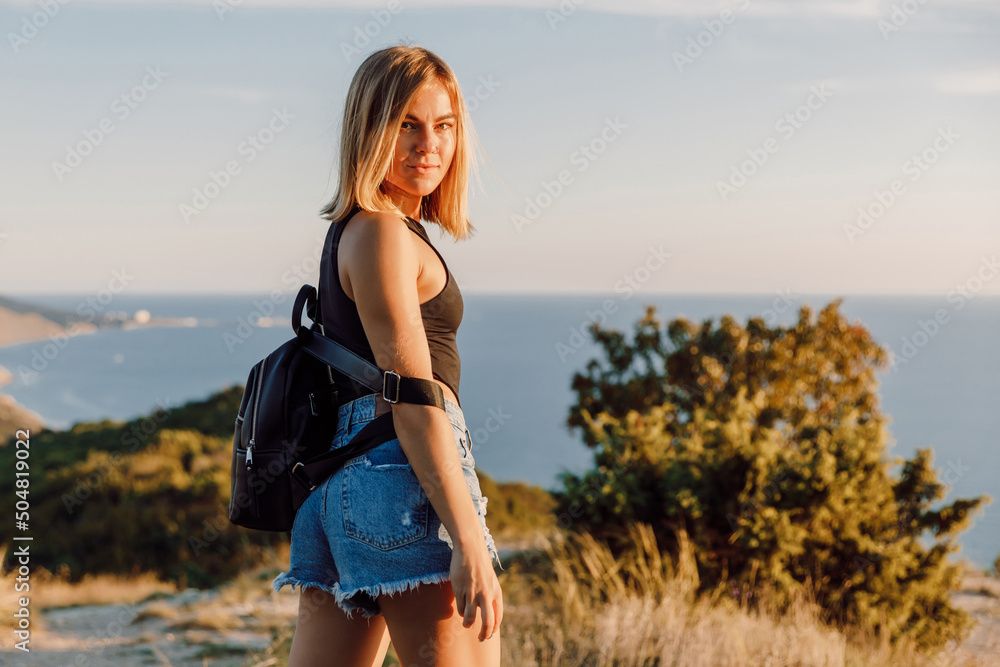 Beautiful sporty woman in shorts posing outdoor. Portrait of girl at nature