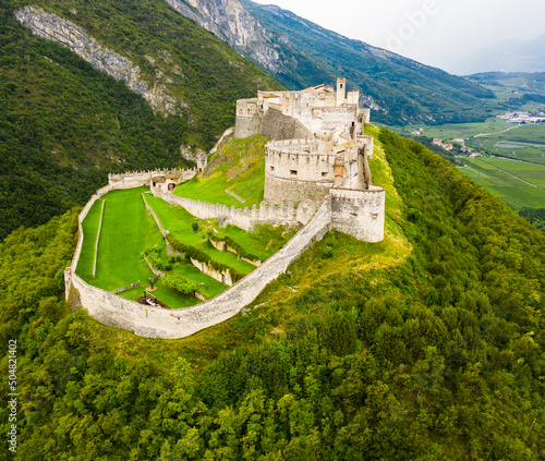 Scenic aerial view of large fortified Beseno castle on top of hill in Besenello, Italy photo