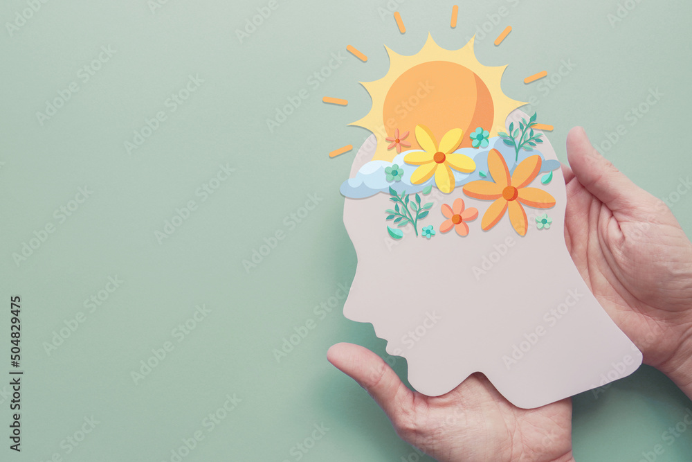 Hands holding paper brain with flowers and sunshine, positive mental health, happy mood, self care concept - obrazy, fototapety, plakaty 