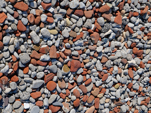 Colorful mixture of pebbles, including red pebbles from broken red bricks eroded by waves