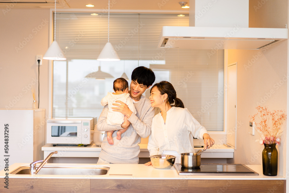 キッチンで料理をするお母さんとお父さんと赤ちゃん