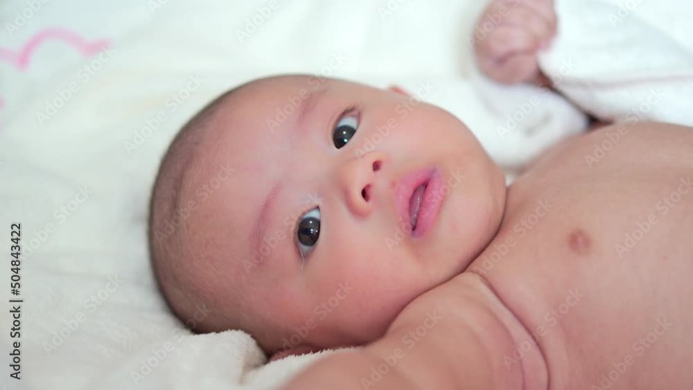 Adorable, Asian newborn lying on bed. Baby boy looking camera with happy face. Little innocent new infant child in first day of life. Mother day concept. Adorable, Asian newborn lying on bed. Baby boy looking camera with happy face. Little innocent new infant child in first day of life. Mother day concept.