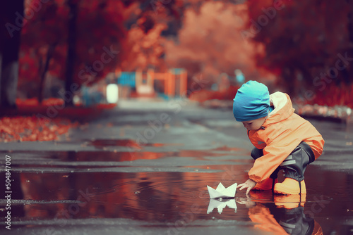 autumn in the park little boy walking in a raincoat seasonal look