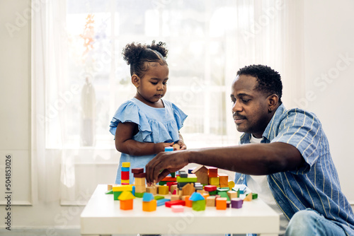 Portrait of happy love black family african american father with little girl smiling activity learn and skill brain training play with toy build wooden blocks board education game at home.father day