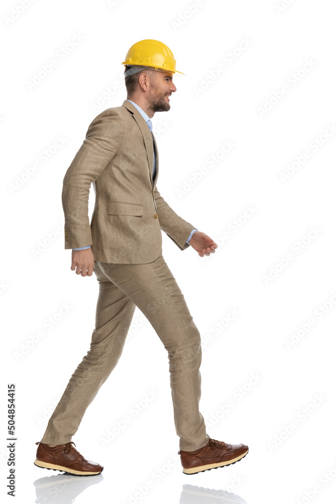 side view of businessman in suit with helmet looking to side side view of businessman in suit with helmet looking to side