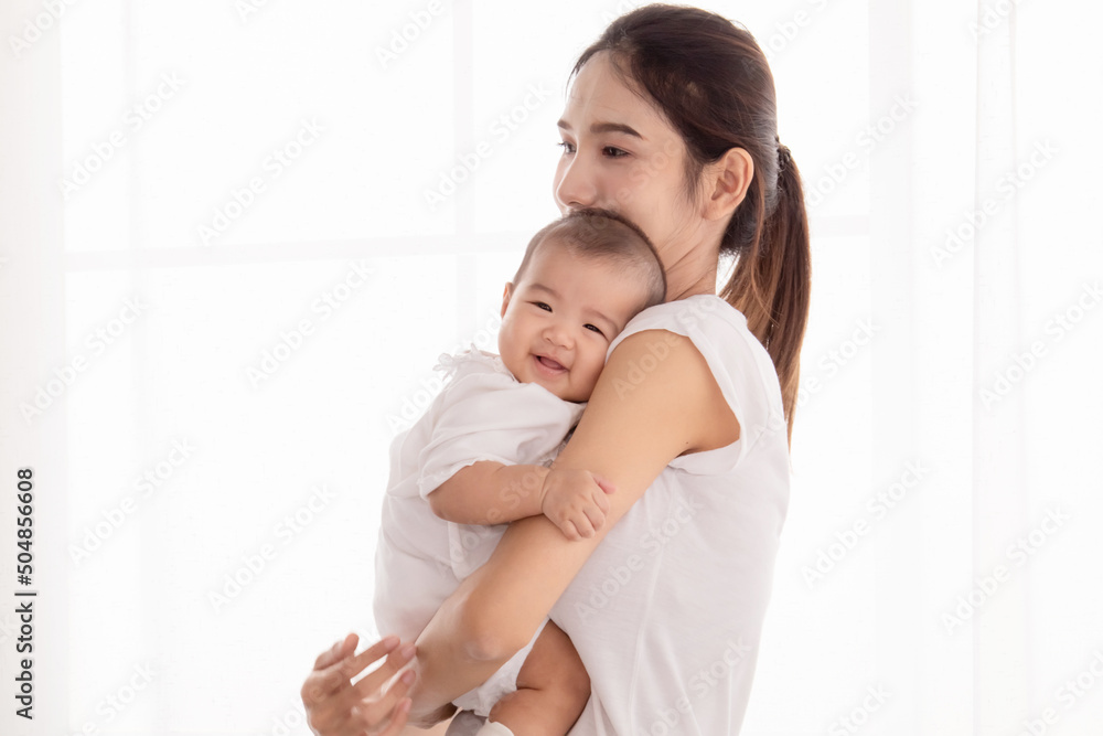 Beautiful Asian mother hold and embrace her todlder, mom looking her baby with love and tender, infant looking at camera and happiness, little girl smiling at camera. Beautiful Asian mother hold and embrace her todlder, mom looking her baby with love and tender, infant looking at camera and happiness, little girl smiling at camera.
