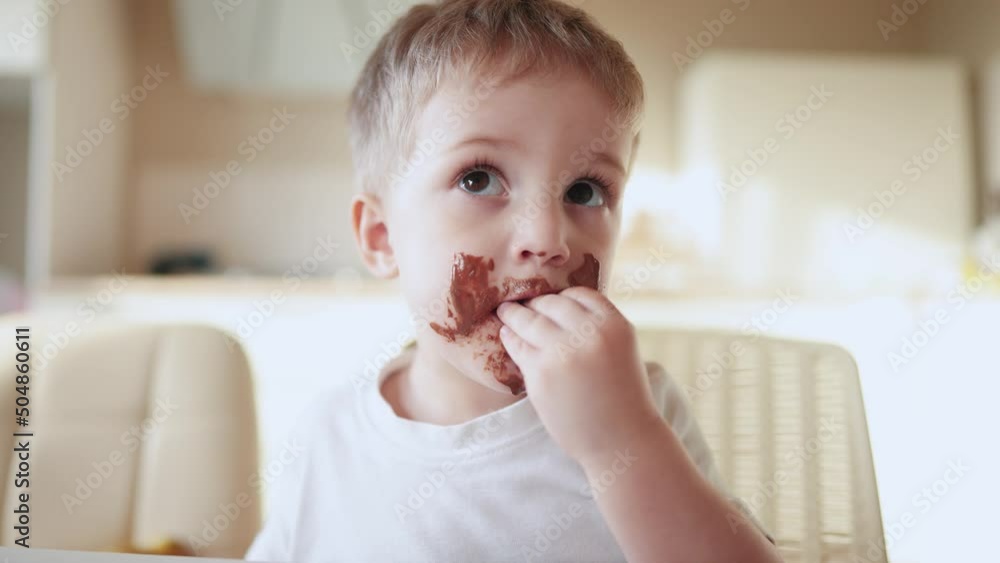 baby boy eat chocolate. dirty little baby kids in the kitchen eating chocolate in the morning. happy family eating sweets kid dream lifestyle concept. baby dirty face eating chocolate cocoa baby boy eat chocolate. dirty little baby kids in the kitchen eating chocolate in the morning. happy family eating sweets kid dream lifestyle concept. baby dirty face eating chocolate cocoa