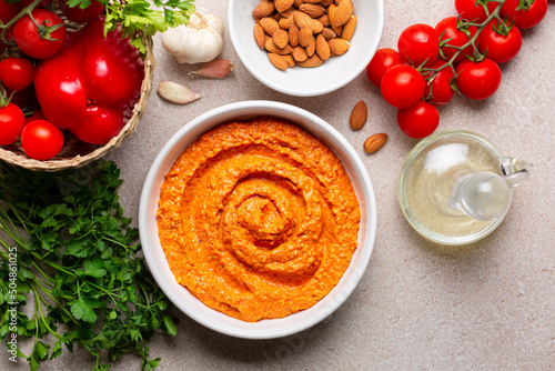 Salsa Romesco and ingredients. Tomato-based Spanish vegetable sauce. Made from mixture of roasted tomatoes, roasted red bell peppers and garlic, toasted almonds, olive oil and bread. Directly above. photo