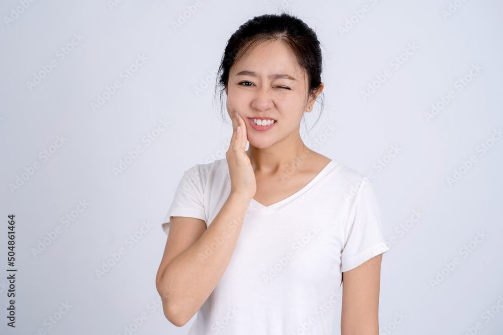 Young Asian woman isolated on white background having a strong teeth pain, molar ache. Young Asian woman isolated on white background having a strong teeth pain, molar ache.
