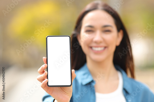 Fotografie Happy woman showing smart phone screen at camera