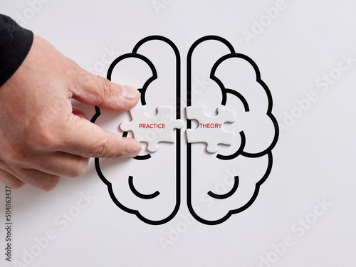 Hand connects the puzzles with the words practice and theory on a human brain symbol.