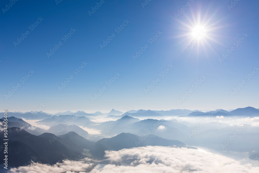 Germany, Bavaria, Summer sun shining over peaks of Bavarian Prealps shrouded in thick fog Germany, Bavaria, Summer sun shining over peaks of Bavarian Prealps shrouded in thick fog
