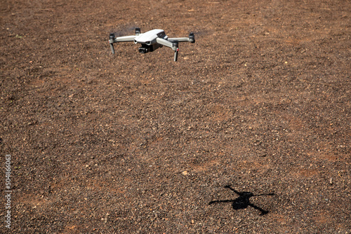 Drone flying over brown terrain full of pebbles