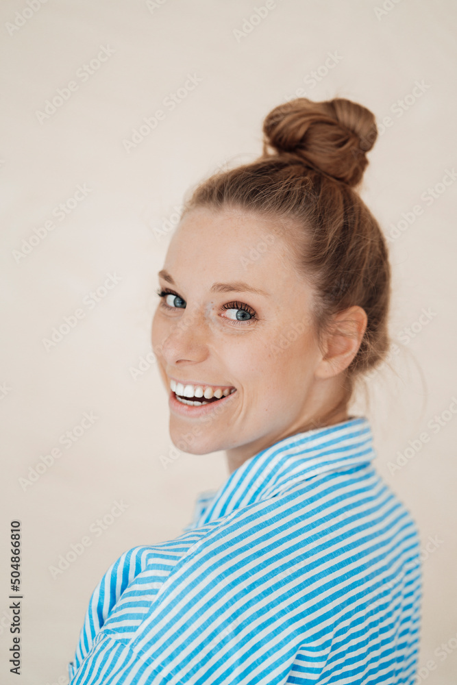 Happy businesswoman with hair bun looking over shoulder Happy businesswoman with hair bun looking over shoulder