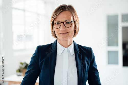 Smiling businesswoman wearing blazer in office photo