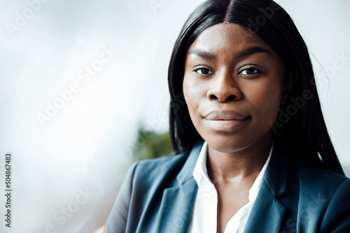 Young confident businesswoman staring at office