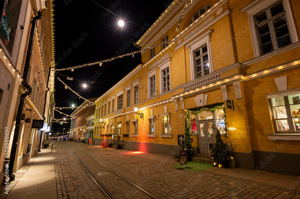 Φωτογραφία Old lit buildings along the almost empty Katariinankatu road at the idyllic and historic Torikorttelit blocks in Helsinki, Finland, at dusk in December