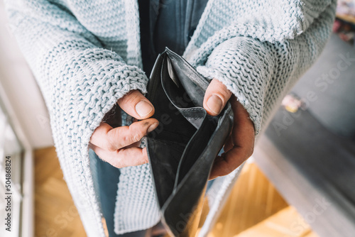 Hands of man wrapped in blanket holding empty wallet photo