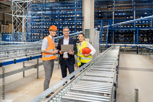 Mature manager with blue-collar workers at factory