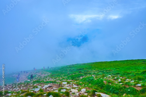 The hikers in mist, Mount Hoverla, Chornohora Range, Carpathians, Ukraine photo