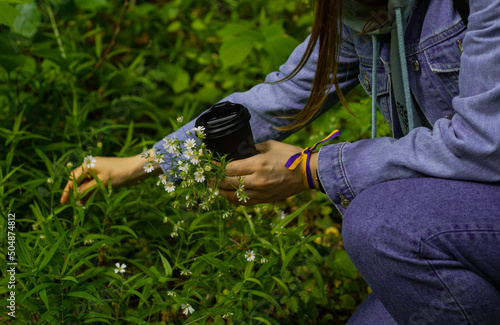 girl in nature collects flowers, relaxing outdoors