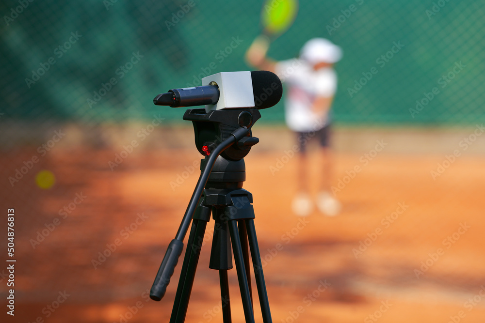 TV industry. A microphone is placed on a video camera tripod with a tennis  match game in background. Sports broadcasting service. Stock Photo | Adobe  Stock