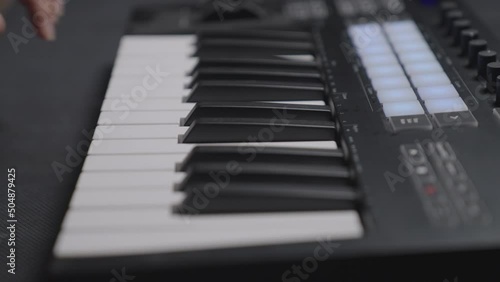 Closeup of male hands composing music using a midi controller launchpad key. photo