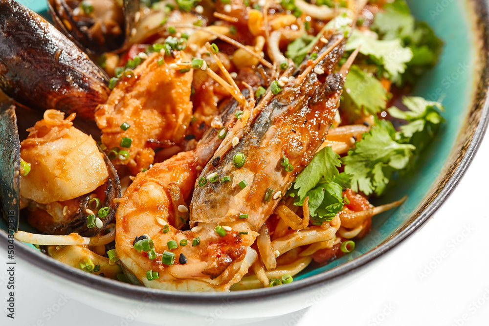 Japanese soba with seafood cooked on wok in asian style on white background. Noodle seafood in ceramic bowl. Indonesian wok with prawn, mussels and soba noodles. Spicy thai dish with shrimp and udon. Japanese soba with seafood cooked on wok in asian style on white background. Noodle seafood in ceramic bowl. Indonesian wok with prawn, mussels and soba noodles. Spicy thai dish with shrimp and udon.