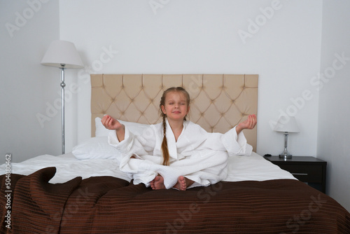 Fototapet Kid girl doing yoga at hotel room