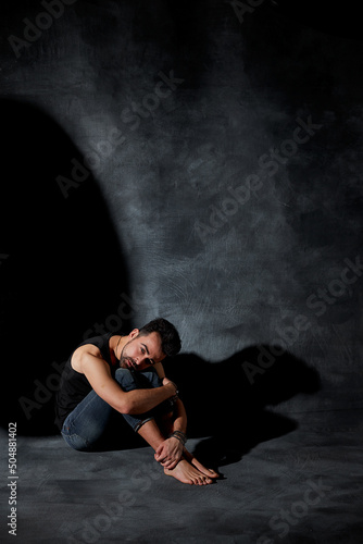 Handsome dark haired man feeling lonely and depressed. Actor playing sadness and crisis.
