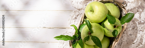 Mele Granny Smith in cestino. Frutta fresca verde su fondo bianco rustico