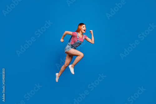 Full body portrait of energetic active person look empty space jump hurry fast isolated on blue color background