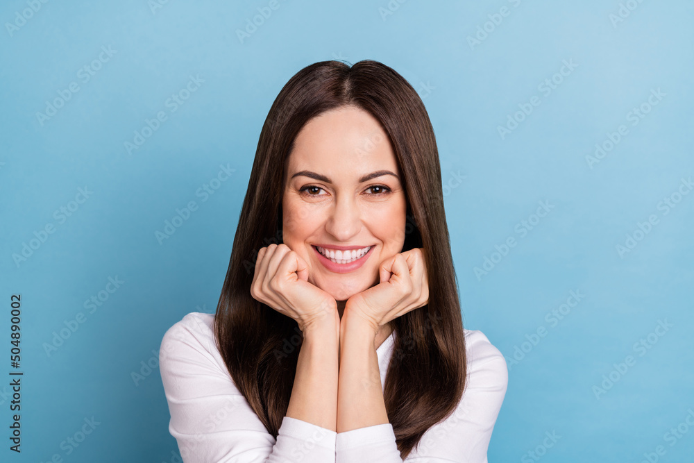 Photo of funny millennial brunette lady hands face wear white pullover isolated on blue color background Photo of funny millennial brunette lady hands face wear white pullover isolated on blue color background