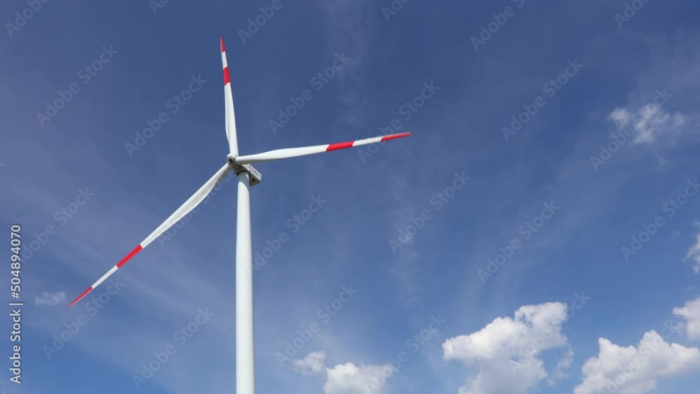 Low angle view on wind generator, turbines, with rotating blades, propellers, against blue sky, renewable clean energy converting kinetic energy. Low angle view on wind generator, turbines, with rotating blades, propellers, against blue sky, renewable clean energy converting kinetic energy.