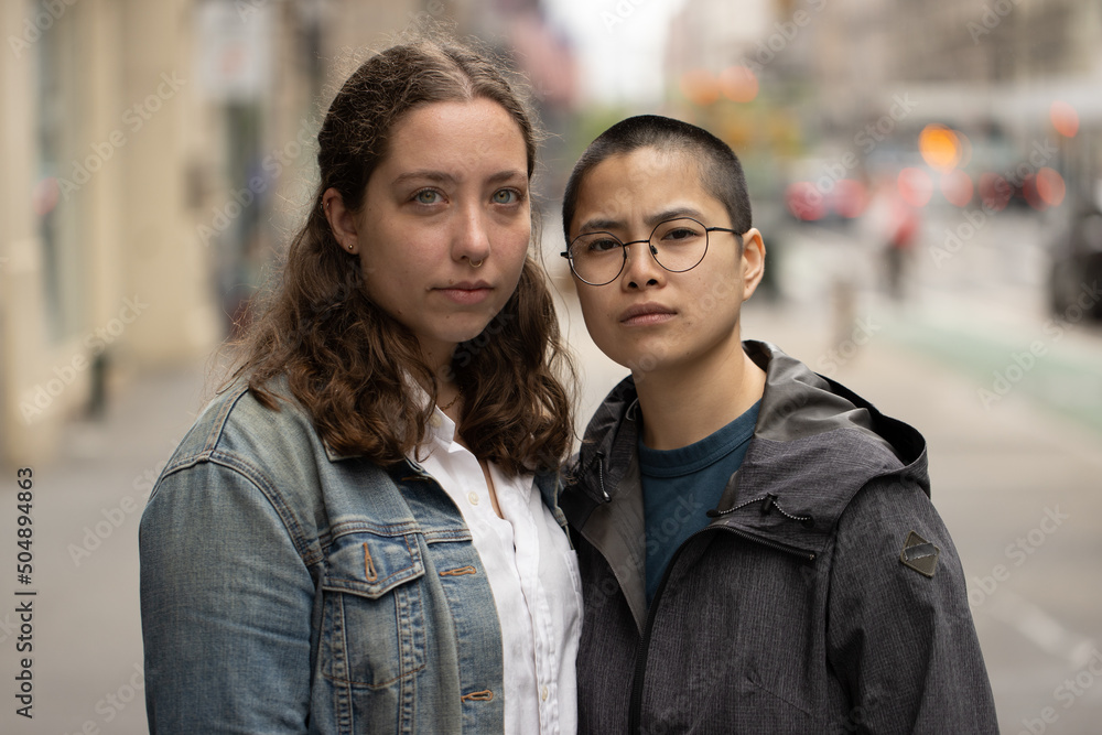 LGBTQ couple on city street serious LGBTQ couple on city street serious