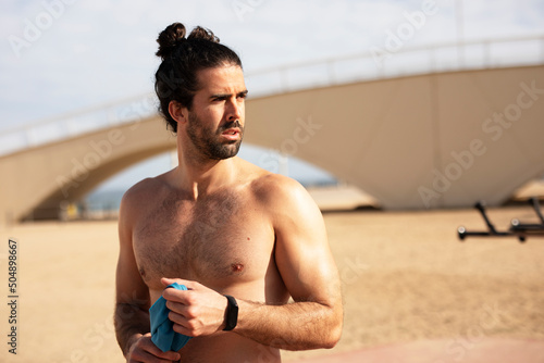 Young athletic man outside. Fit handsome man resting after training. photo