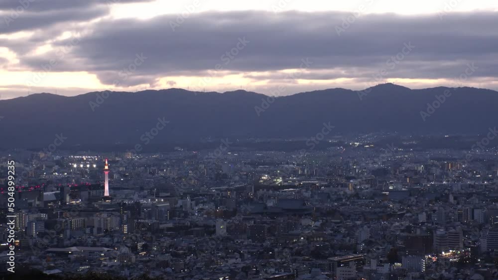 KYOTO, JAPAN - DECEMBER 2021 : Aerial high angle sunset view of Kyoto city. Scenery of mountain, streets and buildings around downtown central area. Long time lapse shot, dusk to night. KYOTO, JAPAN - DECEMBER 2021 : Aerial high angle sunset view of Kyoto city. Scenery of mountain, streets and buildings around downtown central area. Long time lapse shot, dusk to night.
