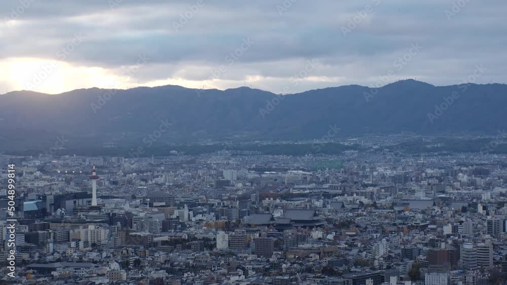 KYOTO, JAPAN - DECEMBER 2021 : Aerial high angle sunset view of Kyoto city. Scenery of mountain, streets and buildings around downtown central area. Long time lapse shot, dusk to night. KYOTO, JAPAN - DECEMBER 2021 : Aerial high angle sunset view of Kyoto city. Scenery of mountain, streets and buildings around downtown central area. Long time lapse shot, dusk to night.